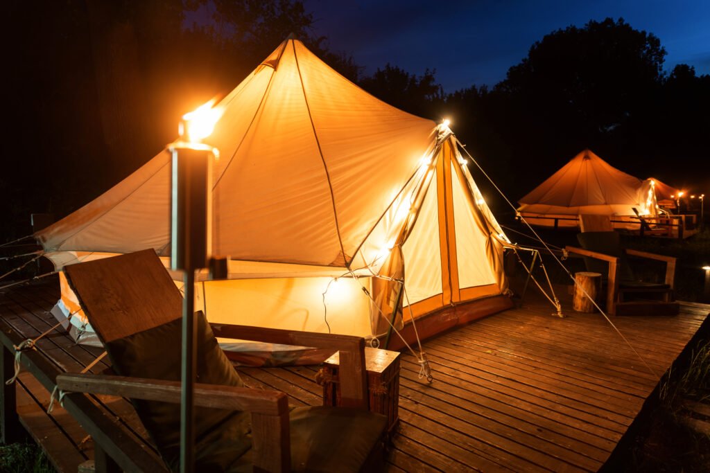 Tiendas safari lodge iluminadas de noche sobre el terreno, ya instaladas y operando