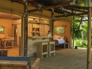 Luxury Suite: bar with stools and the bedroom in the background