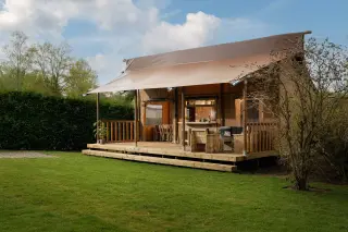 Glamping Lodge 35: family glamping tent on the grass, with a railed terrace