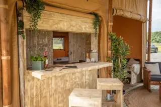 Glamping Lodge 35: wooden bar with stools at the front of the tent