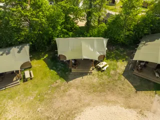 Luxury Safari Lodge: aerial view of three tents on the grass