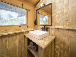 Luxury Safari Lodge: bathroom with a wooden washbasin, a mirror and a window