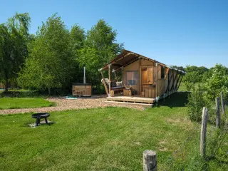 Wood Lodge Cozy: the tent among trees, with a fire pit on the grass