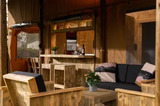 Glamping Lodge 35: living area with a sofa and armchairs facing the bar