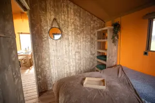 Glamping Lodge 35: bedroom with a round mirror