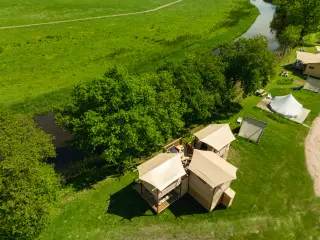 The Village: aerial view next to a river and a meadow